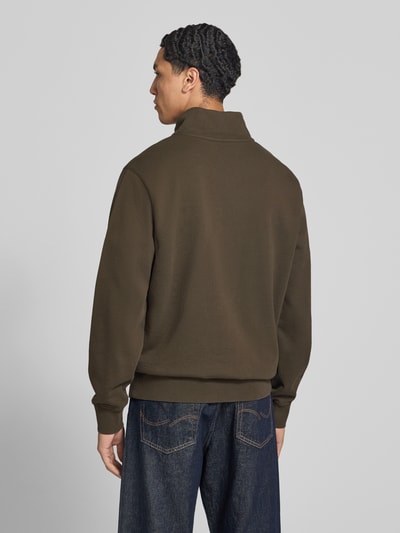Männermodel trägt Regular Fit Troyer aus reiner Baumwolle von Levi's® in Olivgrün, glatte Textur, lockere Form, Ganzkörperansicht Rückansicht.