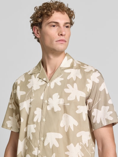 Männermodel trägt Regular Fit Freizeithemd aus Baumwoll-Mix Modell 'Klampo' von Matinique, Beige mit weißen, abstrakten Formen, Nahaufnahme Oberkörper, elastischer Baumwoll-Mix, Reverskragen, kurzärmelig, durchgehende Knopfleiste.