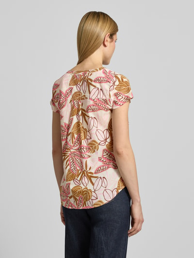 Frauenmodel trägt Relaxed Fit T-Shirt mit floralem Allover-Print von Soyaconcept aus reiner Baumwolle, Tunika-Ausschnitt, Rückenlänge 66 cm, Ärmellänge 14 cm, Ganzkörperansicht Rückansicht.