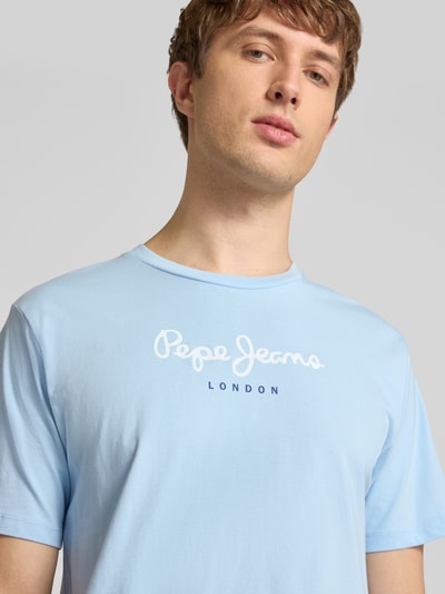 Männermodel trägt Regular Fit T-Shirt aus reiner Baumwolle Modell 'EGGO' von Pepe Jeans in Optik: Unifarben, Label-Print, Rundhals, Jersey, Nahaufnahme Oberkörper.