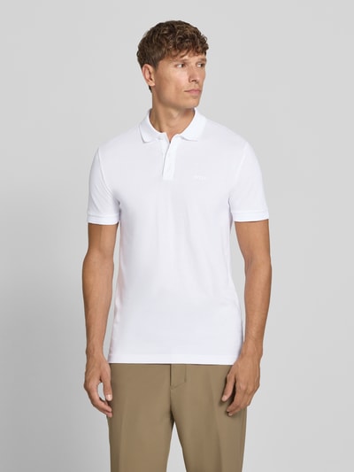 Męskimodel nosi białą koszulkę polo Regular Fit Poloshirt aus reiner Baumwolle model 'PIO 1' von BOSS Green, gładka faktura, Ganzkörperansicht von vorne.