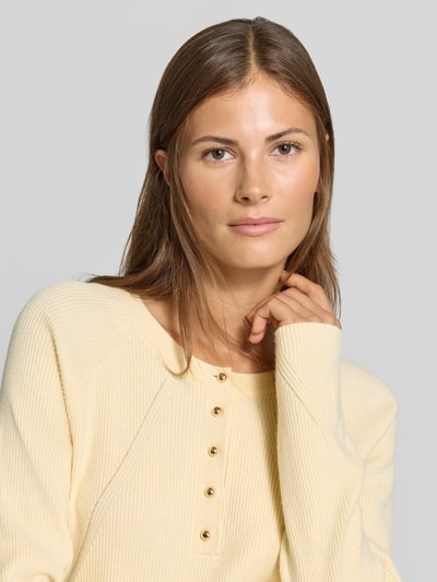 Kobiece model prezentuje bluzkę z długim rękawem Slim Fit Longsleeve aus Strick-Optik od MYON, Imitacja dzianiny, krój slim fit, listwa guzikowa, okrągły dekolt, Długość tyłu w rozmiarze 36: 60 cm, Długość rękawów w rozmiarze 36: 66 cm, kremowy kolor, wyrazista faktura, Nahaufnahme Oberkörper.