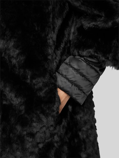 Frauenmodel trägt Mantel aus Kunstfell mit Zweiwege-Reißverschluss von Marc Cain, schwarze Farbe, samtige Struktur, Detailaufnahme, Regular Fit, Stehkragen, KI-modifiziertes Bild