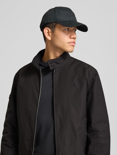Mannelijk model draagt zwarte Regular Fit jack met gestikt logo Model 'HARRINGTON' van Superdry, elastische materiaalmix, opstaande kraag, ritssluiting, Nahaufnahme Oberkörper.
