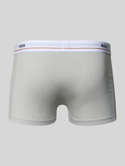 Męski model nosi Slim Fit Trunks aus Baumwoll-Mix im 5er-Pack Modell 5P ESSENTIAL von BOSS, gładki jasnoszary, elastyczny pas, multipack, krój slim fit, widok całej sylwetki od tyłu.