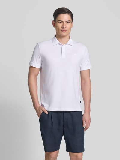Męski model nosi Regular Fit Poloshirt mit Knopfleiste Modell 'Carlosjuan' von JOOP! Collection, mieszanka bawełny z dodatkiem streczu, krój regular fit, kołnierzyk polo, krótka listwa guzikowa, długość tyłu w rozmiarze M: 69 cm, jasny kolor, gładka faktura, proste kształty, Ganzkörperansicht von vorne.