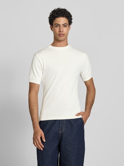Männermodel trägt Slim Fit T-Shirt mit Label-Stitching von PROHIBITED aus Baumwoll-Elasthan-Mix in Weiß, Herren T-Shirt, Ganzkörperansicht von vorne. Rückenlänge bei Größe M: 65 cm, Rundhalsausschnitt.