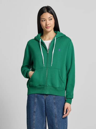 Frauenmodel trägt Regular Fit Sweatjacke aus Baumwoll-Mix von Polo Ralph Lauren in Grün mit weißen Details vor grauem Hintergrund, Ganzkörperansicht von vorne. Damen Sweatjacke von Polo Ralph Lauren.
