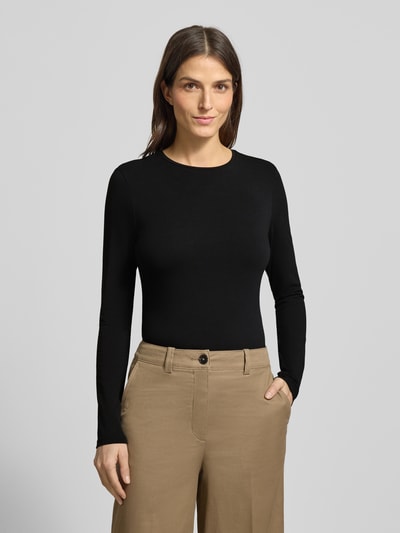 Kobiece modelka nosi bluzkę z długim rękawem z mieszanki bawełny i elastanu, krój slim fit, model 'Smilla' od OPUS, okrągły dekolt, długość tyłu w rozmiarze 36: 63 cm, czarna, gładka faktura, widok całej sylwetki z przodu.