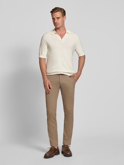 Männermodel trägt Slim Fit Chino aus Baumwoll-Mix von bugatti in Beige, Münztasche und Gesäßtaschen sichtbar, Ganzkörperansicht von vorne.
