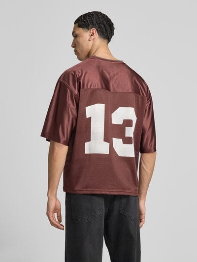 Männermodel trägt T-Shirt in semitransparenter Optik von REVIEW, lockere Passform, V-Ausschnitt, Halbarm, Rückenlänge 67 cm, Ganzkörperansicht Rückansicht.