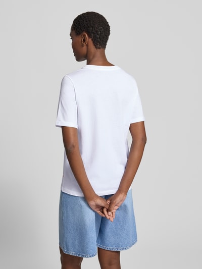 Frauenmodel trägt Regular Fit T-Shirt aus reiner Baumwolle von s.Oliver RED LABEL in Weiß zu heller Jeansshorts, Ganzkörperansicht Rückansicht.