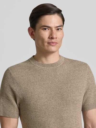 Męski model nosi Strickshirt mit Rundhalsausschnitt Modell 'RILEY' od Jack & Jones Premium, bawełna, krój slim fit, fakturowany wzór, okrągły dekolt, długość tyłu w rozmiarze M: 71 cm, zbliżenie na górną część ciała