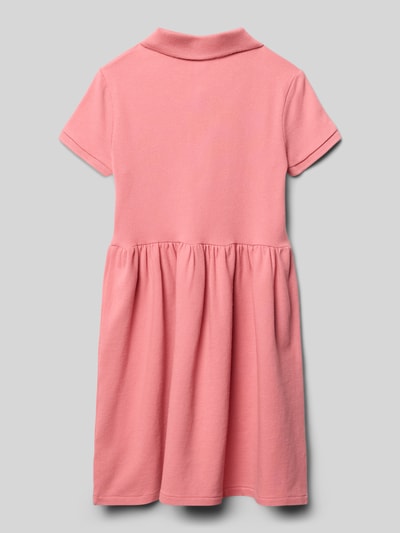Mädchen trägt Polokleid aus Baumwollmix mit Labelstitching von Polo Ralph Lauren Kids, Optik: Unifarben, Materialverarbeitung: Piqué, Kurzarm, Passform: Tailliert, Ganzkörperansicht Rückansicht.