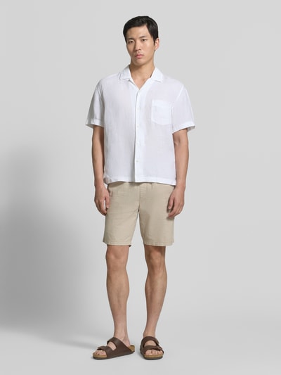 Mężczyznę prezentuje 'Regular Fit Leinenhemd mit Brusttasche und Label-Stitching' od Gant, biały len, kołnierz z połami, krój regular fit, brustasza, wyhaftowane logo, długość tyłu w rozmiarze M 69 cm, szerokość w rozmiarze M 48 cm, długość rękawów w rozmiarze M 24 cm, gładka faktura, jasne kolory, całkowity widok z przodu.