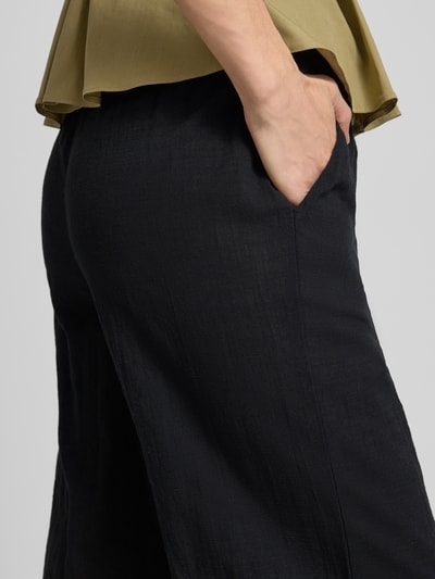 Frauenmodel trägt Weite HOSE aus Baumwoll-Leinen-Mix Modell 'CAIA' von Vero Moda, Optik: Unifarben, seitliche Eingrifftaschen, Nahaufnahme Hüfte.