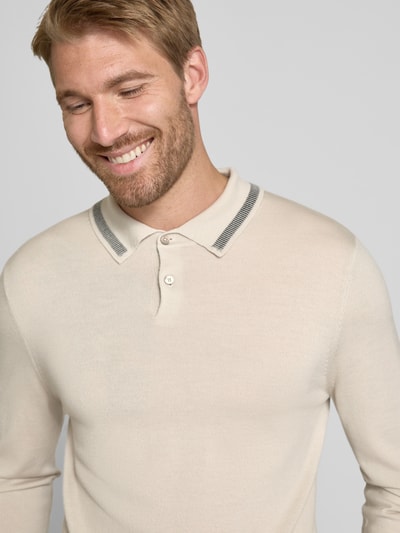Männermodel trägt Regular Fit Poloshirt in Strick-Optik von Paul Smith in Beige mit Polokragen und Label-Stitching, Nahaufnahme Oberkörper, reine Wolle, langärmliges Design, gerippte Abschlüsse, Rückenlänge Größe M 67 cm.
