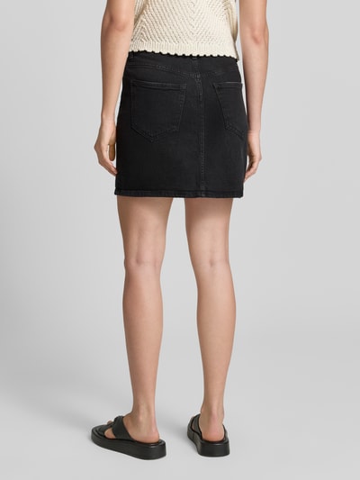 Frauenmodel trägt Regular Fit Jeansrock aus Baumwoll-Mix Modell 'TESSA' von Vero Moda, schwarzer Denim, Twill, 5-Pocket, Ganzkörperansicht Rückansicht.