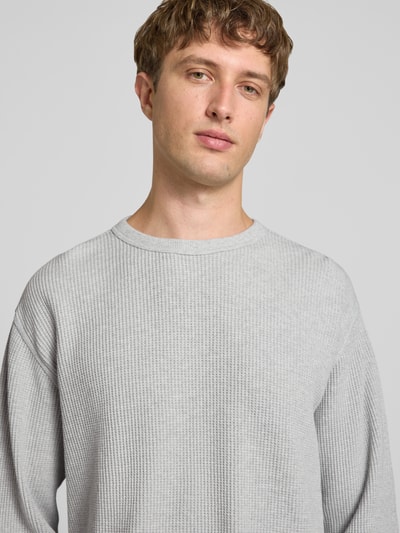 Männermodel trägt Relaxed Fit Langarmshirt aus reiner Baumwolle von Levi's®, hellgrau, feine Waffelstruktur, Nahaufnahme Oberkörper.
