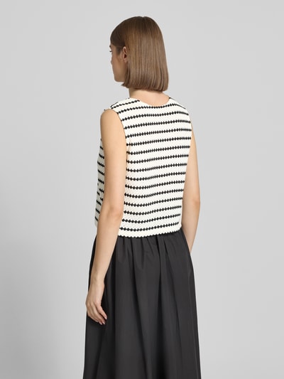 Frauenmodel trägt Regular Fit Weste mit Baumwoll-Anteil Modell 'EVA LIFE' von Only, Allover-Muster in Schwarz-Weiß, Strick, Ganzkörperansicht Rückansicht.