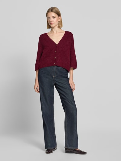 Frauenmodel trägt Strickjacke aus Alpaka-Mix mit Leinen-Anteil Modell 'Thora' von MOS MOSH, dunkles Rot, 3/4-Arm, gerade Passform, V-Ausschnitt, Knopfleiste, Damen Strickjacke, Ganzkörperansicht von vorne.