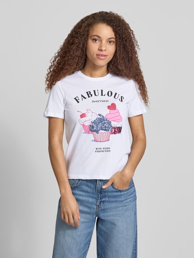 Frauenmodel trägt Damen T-Shirt von Only, Modell 'KITA', Optik: Unifarben, Passform: Shaped Fit, Motiv-Print mit Pailletten und Strasssteinen, Rundhals, Kurzarm, Jersey aus reiner Baumwolle, Weiß mit buntem Print, Ganzkörperansicht von vorne.