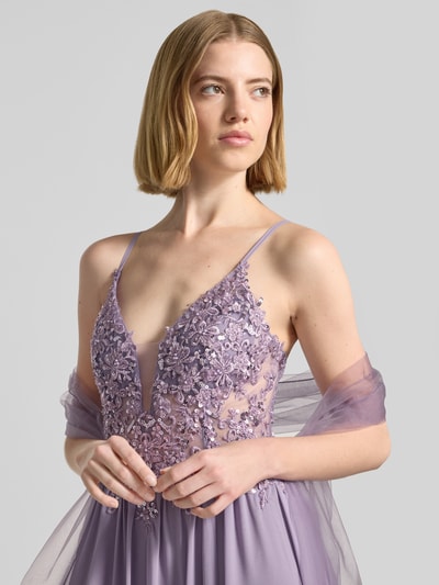 Frauenmodel trägt Abendkleid mit Spitze und Strasssteinbesatz von Mascara aus fliederfarbenem Chiffon, V-Ausschnitt, Nahaufnahme Oberkörper. Rückenlänge bei Größe 36: 132 cm, Brustweite bei Größe 36: 40 cm, rückseitige Spaghettiträger, Schnürung, Haken- und Reißverschluss.