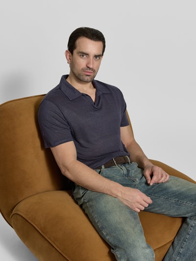 Männermodel trägt Regular Fit Poloshirt aus reinen Leinen von Officine Générale in Dunkelblau, semitransparent, kurzärmelig, Nahaufnahme Oberkörper.