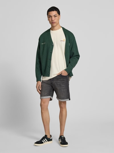 Männermodel trägt Regular Fit Jeansshorts mit Umschlag Modell 'RICK' von Jack & Jones im Used-Look, Baumwoll-Mix mit Stretch-Anteil, Ganzkörperansicht von vorne.