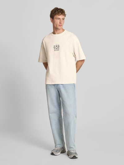 Męski model nosi T-Shirt mit Label-Stitching und Rundhalsausschnitt von REVIEW, bawełna, krój relaxed fit, Długość tyłu w rozmiarze M: 69 cm, jasne kolory, prosta faktura, Ganzkörperansicht von vorne.