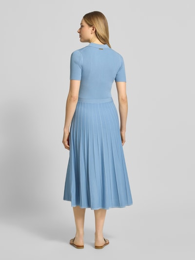 Frauenmodel trägt Midikleid aus Viskose mit Polokragen und Knopfleiste von MICHAEL Michael Kors in Hellblau, strukturierte Ripptextur, A-Linien-Form, kurze Ärmel, Rückenlänge 118 cm, Brustweite 32 cm, Ärmellänge 22 cm, Ganzkörperansicht Rückansicht.