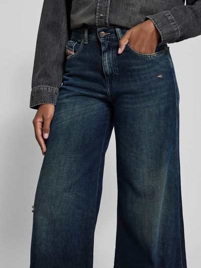 Frauenmodel trägt Wide Fit Jeans mit 5-Pocket-Design von Diesel aus Baumwoll-Lyocell-Mix, lockerer Schnitt, Label-Detail, Nahaufnahme Oberkörper.