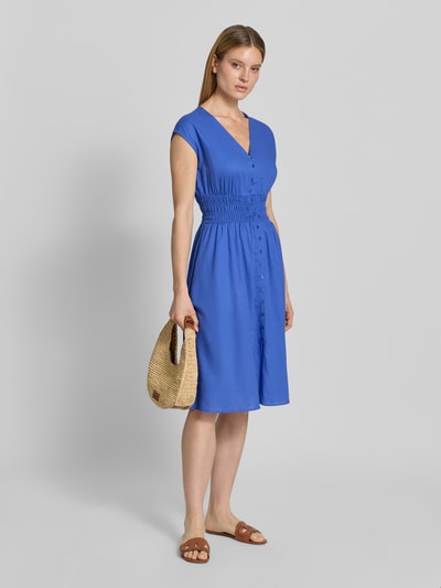 Modelka kobieca nosi 'Knielanges Kleid aus Leinen-Mix mit Knopfleiste' od Christian Berg Woman Selection, niebieski, długość do kolan, fason taliowany, dekolt V, krótkie rękawy, guziki, smokowane detale, mieszanka lnu i wiskozy, Szerokość w rozmiarze 36: 44 cm, długość tyłu: 44 cm, widok całej sylwetki z przodu.