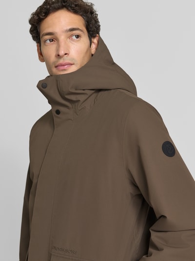Männermodel trägt Regular Fit Jacke mit aufgesetzten Taschen Modell 'Liam' von Didriksons in Braun, glatte Textur, Nahaufnahme Oberkörper. Herren Jacke, Kapuze, Rückenlänge 79 cm, Schulterbreite 44 cm, Brustweite 45 cm, Ärmellänge 70 cm.
