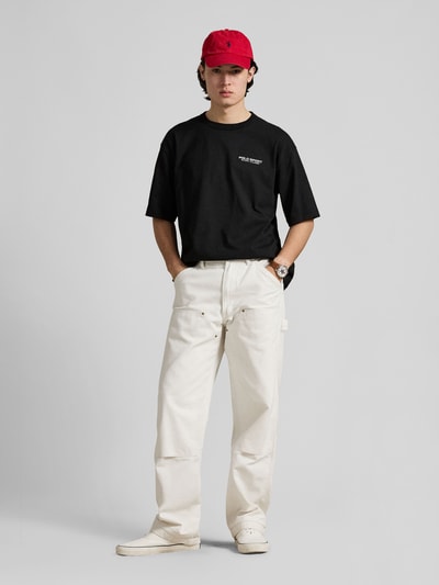 Mannelijk model draagt Regular Fit T-Shirt uit zuivere katoen van Polo Ralph Lauren in effen zwart met labelprint, ronde hals en korte mouwen, vooraanzicht volledige lichaamsopname.