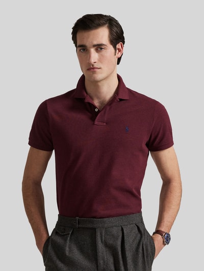 Männermodel trägt Slim Fit Poloshirt aus reiner Baumwolle von Polo Ralph Lauren in Dunkelrot und Grau, Nahaufnahme Oberkörper.
