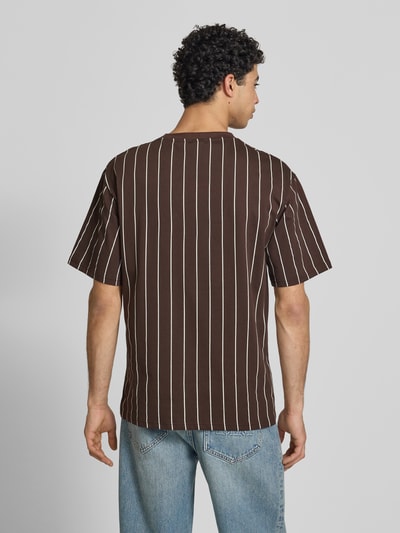Männermodel trägt Regular Fit T-Shirt mit Logo-Stitching von KARL KANI, braun mit weißen Streifen, Reine Baumwolle, Rückenlänge 85 cm, Ganzkörperansicht Rückansicht.