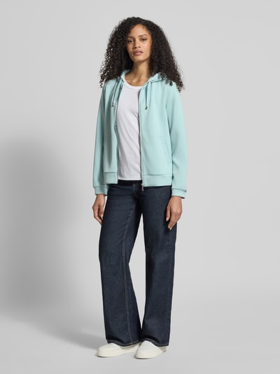 Kobiece modelka nosi Regular Fit Sweatjacke mit Viskose-Anteil von Tom Tailor, efekt: jednolity kolor, krój regular fit, zamek błyskawiczny, nadruk z logo na tunelu, kaptur z tunelem, długie rękawy, wykończenie z bocznymi rozcięciami, kieszenie boczne wpuszczane; pełny widok z przodu.