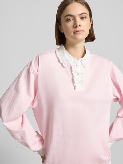 Frauenmodel trägt Oversized Poloshirt mit Kontrastbesatz Modell 'Jolina' von OH APRIL in Rosa, Reine Baumwolle, Langärmlig, Nahaufnahme Oberkörper.