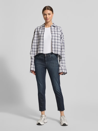 Kobiece modelka nosi Slim Fit Jeans im 5-Pocket-Design Modell 'ORNELLA' od Angels, mieszanka bawełny z dodatkiem streczu, krój slim fit, skrócony fason, ciemnoniebieski kolor, guziki i zamek błyskawiczny, szerokość w rozmiarze 36: 40 cm, długość wewnętrzna nogawki w rozmiarze 36: 66 cm, widok całej sylwetki z przodu.
