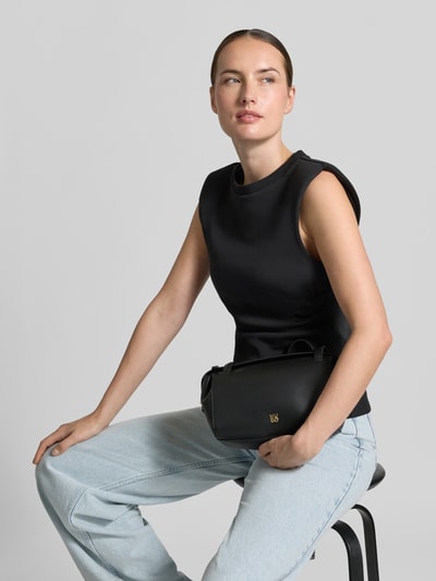 Vrouwenmodel draagt zwarte Henkeltasche in leerlook model 'Meelo_Duffle SM' van HUGO, Dames, metaalaccent, detailopname Oberkörper
