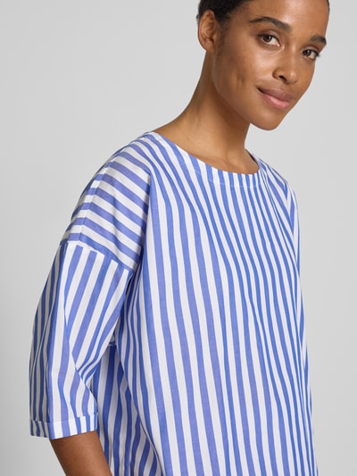 Frauenmodel trägt Relaxed Fit Bluse mit U-Boot-Ausschnitt von Rich & Royal, Reine Baumwolle, Halbarm, blau-weiß gestreift, Nahaufnahme Oberkörper.