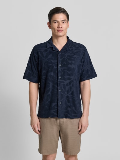 Männermodel trägt Regular Fit Freizeithemd aus Baumwoll-Mix Modell 'WE_FLOWER' von BOSS Orange, Optik: Unifarben, Strukturiert, Strukturmuster, Label-Stitching, Vario-Kragen, durchgehende Knopfleiste, Kurzarm, Materialverarbeitung: Frottee, Ganzkörperansicht von vorne.