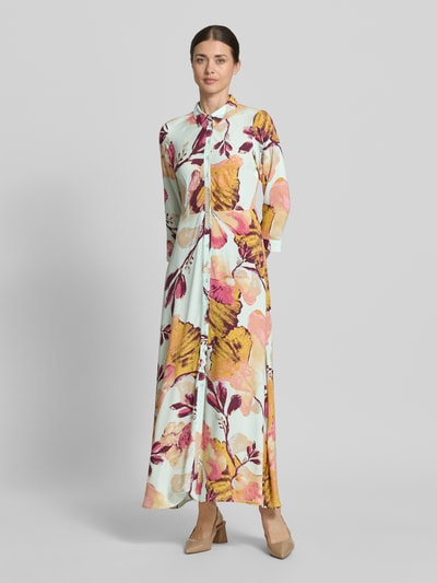 Kobiece modelka nosi Hemdblusenkleid aus Viskose mit Knopfleiste Modell 'SAVANNA' von YAS, kolorowe kwiaty, a-linia, maxidługość, szerokość w rozmiarze S 47 cm, długość tyłu 140 cm, długość rękawa 49 cm, widok całej sylwetki z przodu