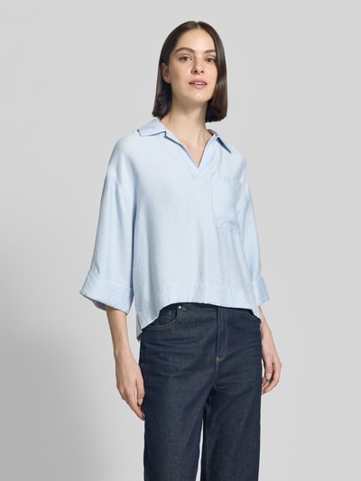 Vrouwenmodel draagt lichtblauwe dames blouse van modalmix, platte kraag, V-hals, borstzak, model 'Felmara' van OPUS, loose fit, verlengde rug, mouwen met omslag, modalmix, ganzkörperansicht van voren.
