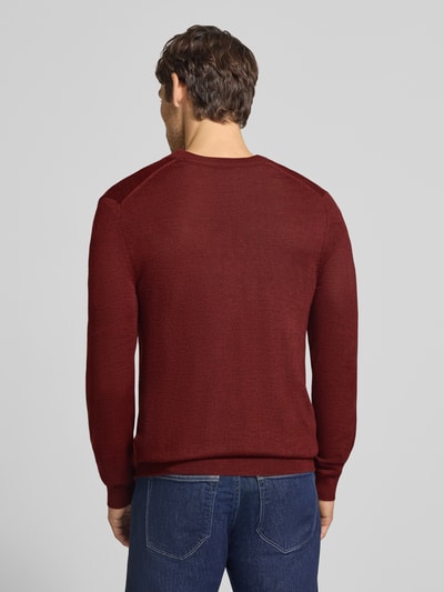 Männermodel trägt Cardigan aus Woll-Mix mit V-Ausschnitt von Christian Berg Men in Dunkelrot, körpernah, glatte Textur, Ganzkörperansicht Rückansicht.