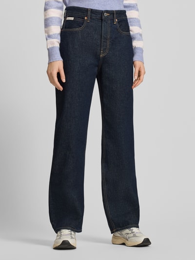 Frauenmodel trägt Straight Fit Jeans mit Label-Detail von Calvin Klein Jeans in Dunkelblau, Reine Baumwolle, Ganzkörperansicht von vorne, Modell THE STRAIGHT BOOT RESIN, Bundweite 37 cm, Innenbeinlänge 80 cm.
