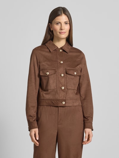 Kobieta modelka nosi kurtkę 'Jacke mit Umlegekragen' od Oui, elastyczna mieszanka materiałów, prosty krój, nakładane kieszenie, zapięcie na guzik, brązowa, długość tyłu w rozmiarze 36: 49 cm, szerokość ramion w rozmiarze 36: 39 cm, szerokość klatki piersiowej w rozmiarze 36: 43 cm, długość rękawów w rozmiarze 36: 61 cm, widok całej sylwetki z przodu