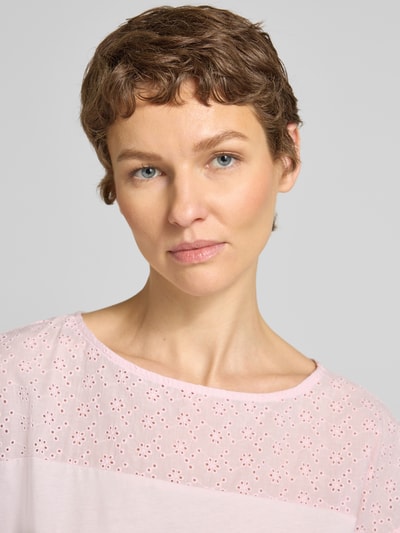 Frauenmodel trägt Regular Fit Blusentop aus reiner Baumwolle Modell 'JANNI' von Vero Moda, Optik: Unifarben, semitransparenter Besatz, U-Boot-Ausschnitt, Ärmelform: Kurzarm, Materialverarbeitung: Jersey, Farbe Rosa, Nahaufnahme Oberkörper.