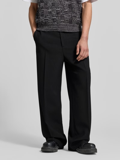 Männermodel trägt Relaxed Fit stoffen broek uit wolmix van Filippa K, bandplooien, steek- en achterzakken, knoop- en ritssluiting, zwart, binnenbeenlengte 80 cm, bandwijdte 40 cm, Ganzkörperansicht van voren.
